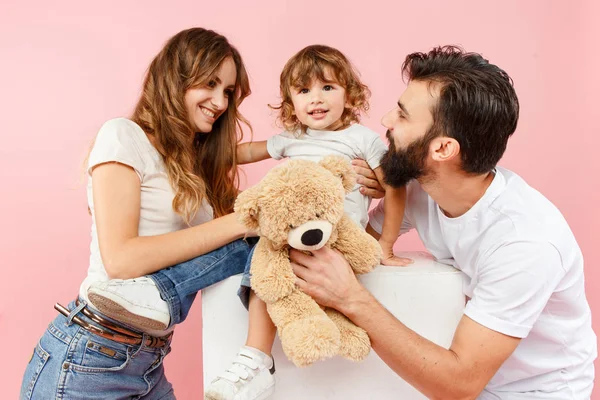 Una familia feliz sobre fondo rosa — Foto de Stock