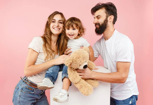 Una familia feliz sobre fondo rosa — Foto de Stock