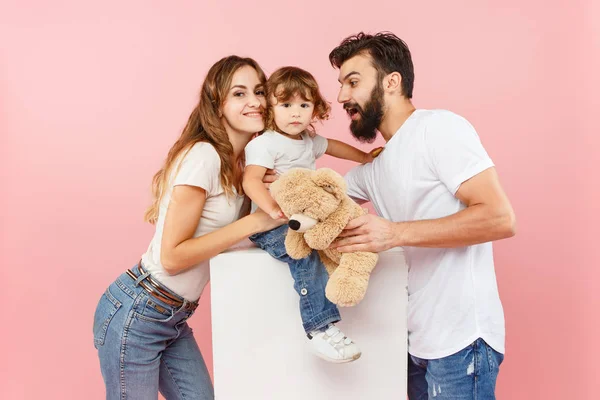 Una familia feliz sobre fondo rosa — Foto de Stock