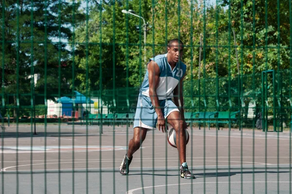 Imagen de un joven jugador de baloncesto africano confuso practicando —  Fotos de Stock