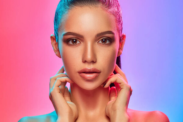 High Fashion model woman in colorful bright lights posing in studio