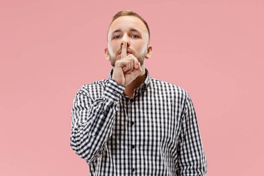 Pembe arka plan üzerinde elini arkasındaki sır fısıldayan genç adam