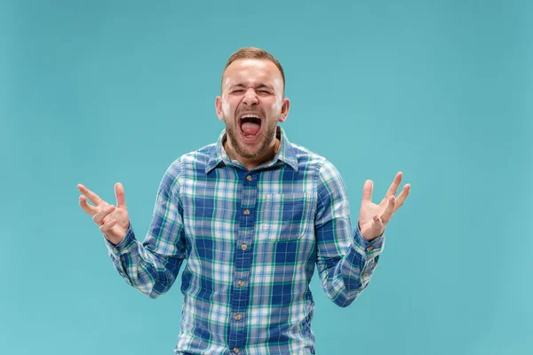 Il giovane uomo arrabbiato emotivo urla sullo sfondo dello studio — Foto Stock