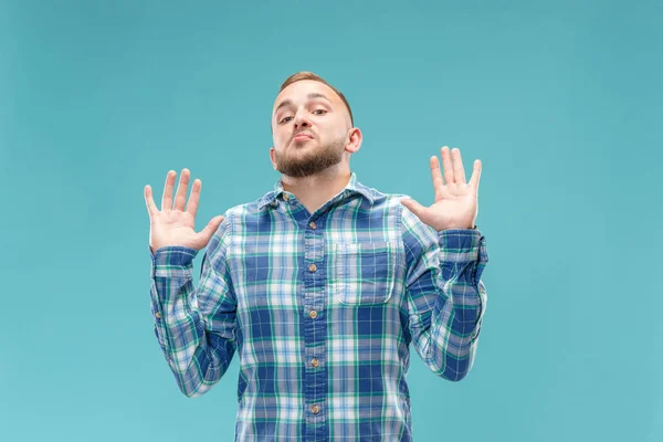 Bonito homem olhando surpreendido e desnorteado isolado em azul — Fotografia de Stock