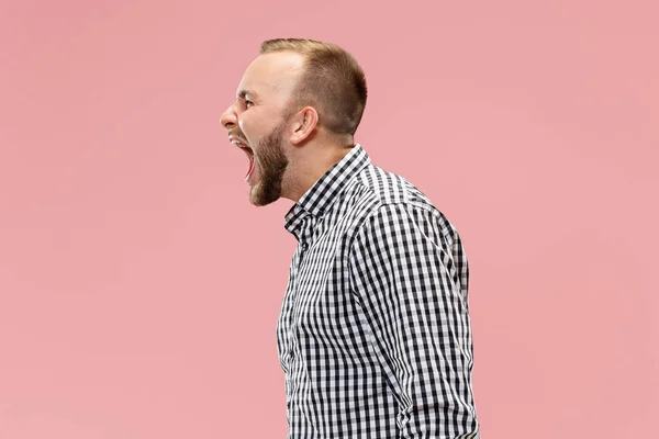 De jonge emotionele boos man schreeuwen op studio achtergrond — Stockfoto