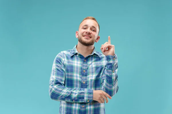 Den glada affärsman står och ler mot blå bakgrund. — Stockfoto