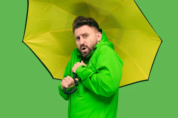 Schöner bärtiger junger Mann mit Regenschirm und Blick in die Kamera isoliert auf weiß — Stockfoto