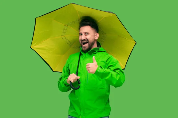 Handsome bearded young man holding umbrella and looking at camera isolated on white — Stock Photo, Image