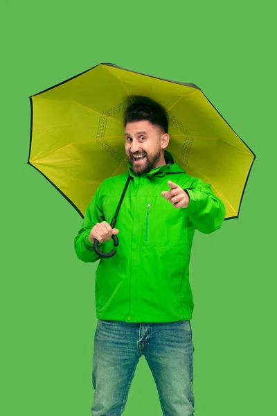 Schöner bärtiger junger Mann mit Regenschirm und Blick in die Kamera isoliert auf weiß — Stockfoto