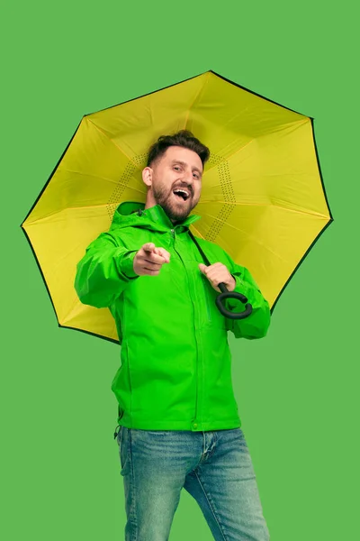 Schöner bärtiger junger Mann mit Regenschirm und Blick in die Kamera isoliert auf weiß — Stockfoto