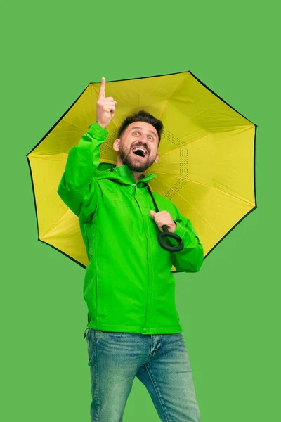 Guapo barbudo joven sosteniendo paraguas y mirando a la cámara aislada en blanco — Foto de Stock