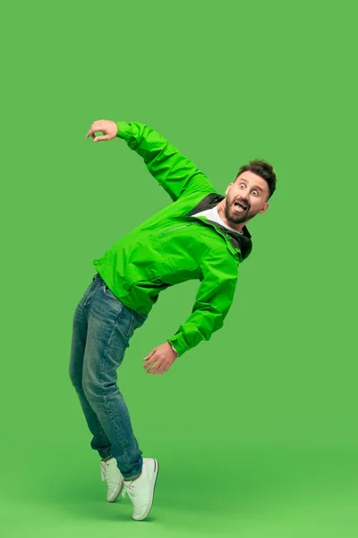Hezký vousatý mladík při pohledu na fotoaparát izolované na zelené — Stock fotografie