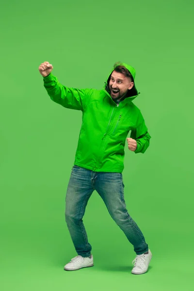 Handsome bearded young man looking at camera isolated on green — Stock Photo, Image