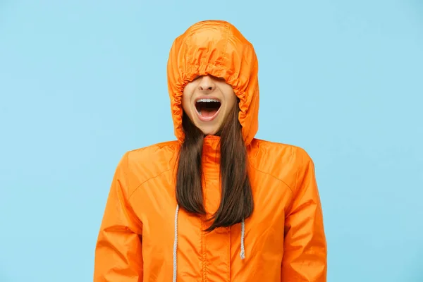 The young surprised couplel posing at studio in autumn jackets isolated on blue — Stock Photo, Image