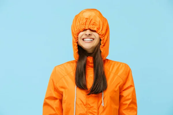 La joven pareja sorprendida posando en el estudio en chaquetas de otoño aisladas en azul —  Fotos de Stock