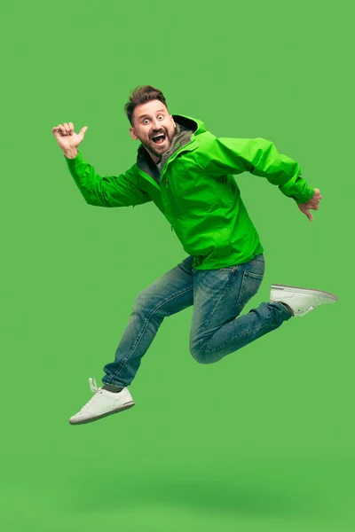 Guapo barbudo joven corriendo aislado en verde — Foto de Stock