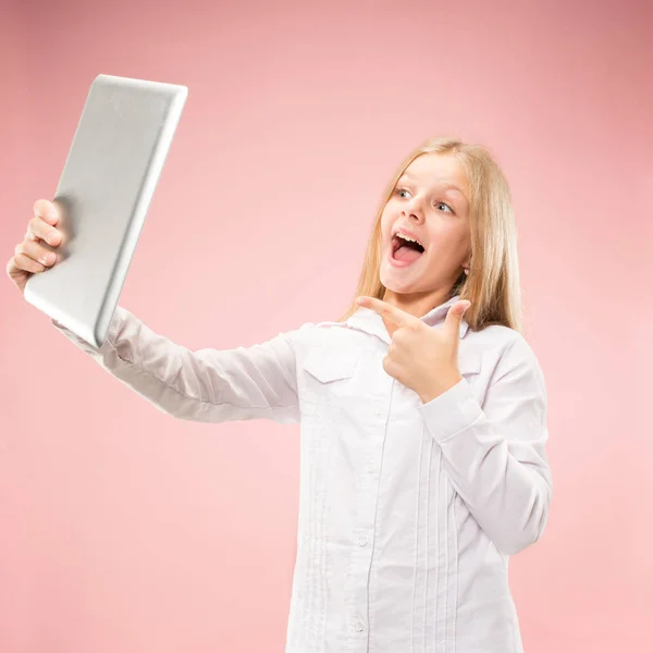 Tiener meisje met laptop. Dol op computer concept. Aantrekkelijke vrouwelijke halve lengte front portret, trendy roze studio achtergrondgeluid. — Stockfoto
