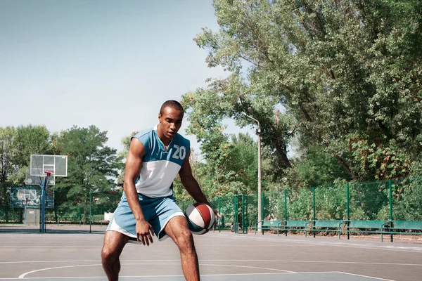 Picture of young confused african basketball player practicing