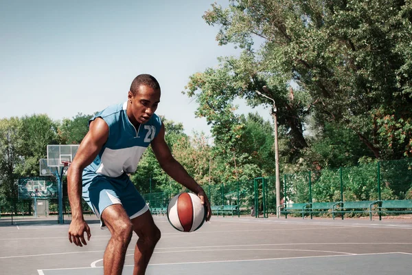 Imagen de un joven jugador de baloncesto africano confuso practicando —  Fotos de Stock