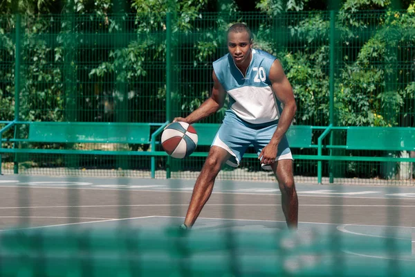 Imagen de un joven jugador de baloncesto africano confuso practicando —  Fotos de Stock