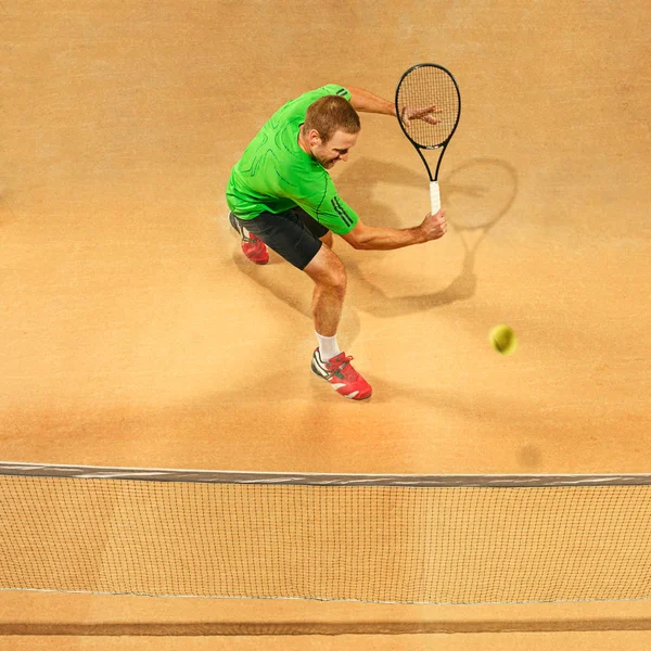 El jugador de salto, hombre caucásico en forma, jugando al tenis en la cancha de tierra —  Fotos de Stock