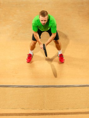 Bir atlama oyuncu, beyaz adam, toprak kortta tenis oynamaya uygun.