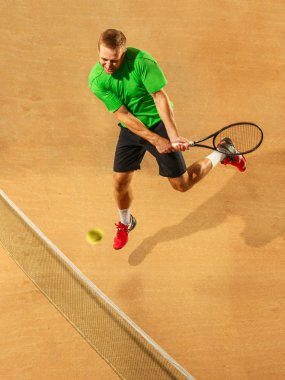 Bir atlama oyuncu, beyaz adam, toprak kortta tenis oynamaya uygun.