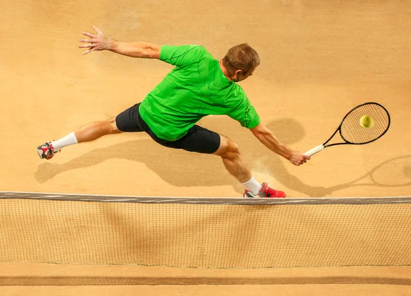Jeden gracz skoki, Kaukaska zmieścić człowiek, grając w tenisa na glinianym korcie — Zdjęcie stockowe