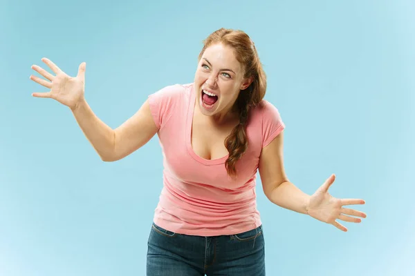 Młoda kobieta zły emocjonalne krzyczy na tle niebieski studio — Zdjęcie stockowe