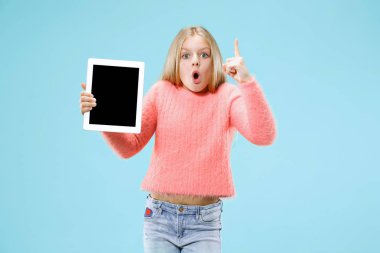 Küçük kız mavi stüdyo zemin üzerine tablet ile. O bir şeyler gösteriyor ve yukarı dönük
