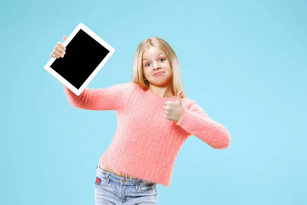 Pequeña chica divertida con la tableta sobre fondo azul — Foto de Stock