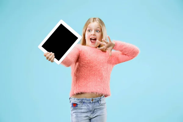 Legrační holčička s tabletem na modrém pozadí — Stock fotografie