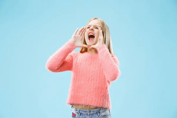 Ізольовані на синій молодий випадковий підліток дівчина кричить в студії — стокове фото