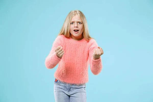 Retrato de menina adolescente com raiva em um fundo de estúdio azul — Fotografia de Stock