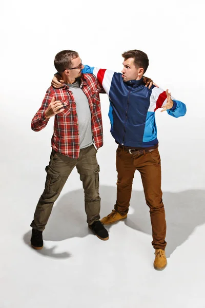 Dos amigos en casual colorido desgaste de pie y riendo juntos . — Foto de Stock