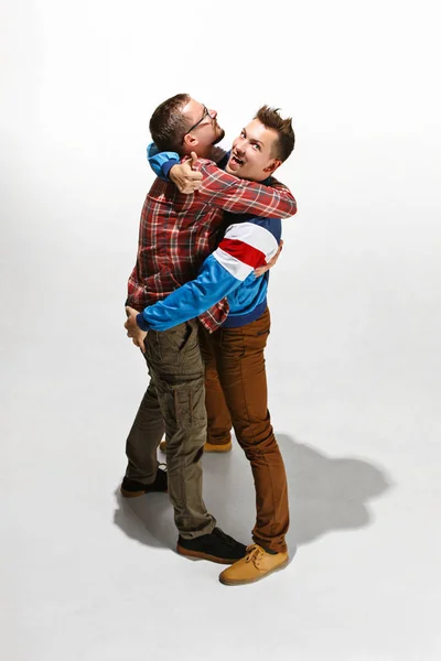Deux amis en tenue décontractée colorée debout et riant ensemble . — Photo