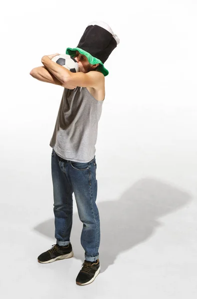 Молодий фанат футболу чоловік обіймає футбольний м'яч ізольовано на білому тлі — стокове фото