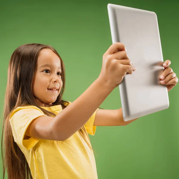 Дівчина-підліток з ноутбуком. Любов до концепції комп'ютера. Привабливий жіночий портрет напівдовжини, модний зелений студійний фон . — стокове фото