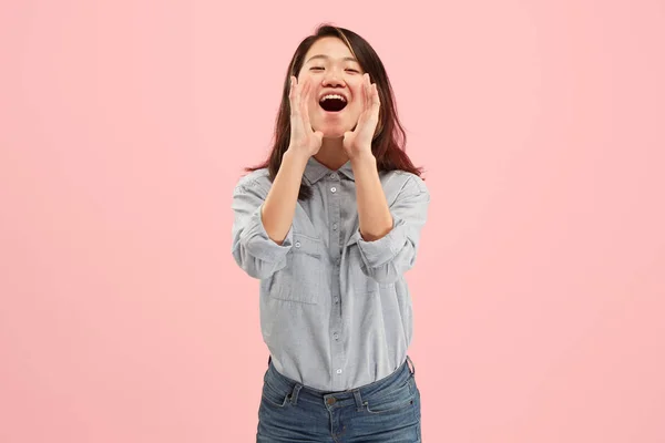 Geïsoleerd op roze jonge casual vrouw schreeuwen in studio — Stockfoto