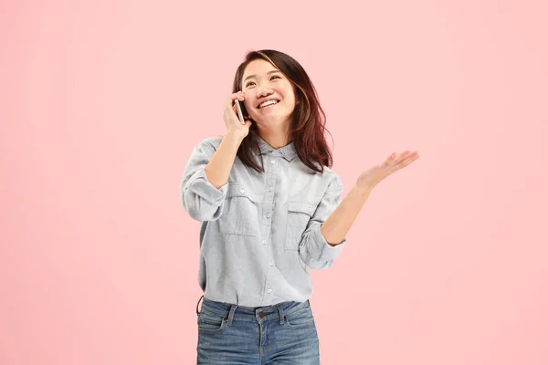 Mujer hermosa joven usando estudio de teléfono móvil sobre fondo de color rosa —  Fotos de Stock