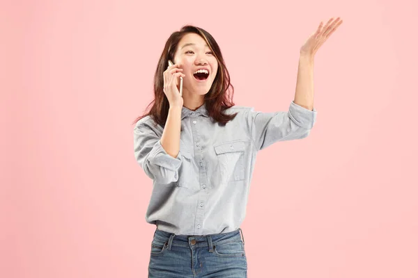 Jovem mulher bonita usando estúdio de telefone móvel no fundo cor-de-rosa — Fotografia de Stock