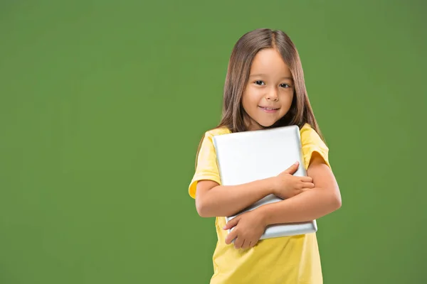 Chica adolescente con portátil. Me encanta el concepto de computadora. Atractivo retrato frontal femenino de media longitud, fondo de estudio verde de moda . — Foto de Stock