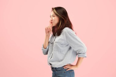 Pembe arka plan üzerinde elini arkasındaki sır fısıldayan genç kadın