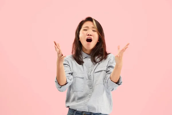 A jovem mulher irritada emocional gritando no fundo do estúdio rosa — Fotografia de Stock