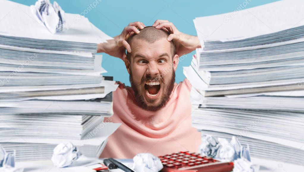 Frustrated overwhelmed executive working in the office and overloaded with paperwork