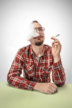 Yakışıklı hipster adam evde sigara içilmeyen. Yukarı doğru seyir ve ücretsiz zaman geçirmekten zevk adam.