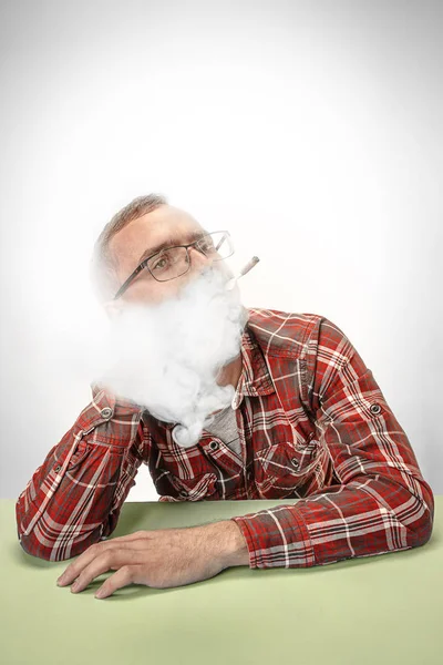 Bonito hipster fumando cigarro em casa. Homem olhando para cima e desfrutando de passar o tempo livre . — Fotografia de Stock