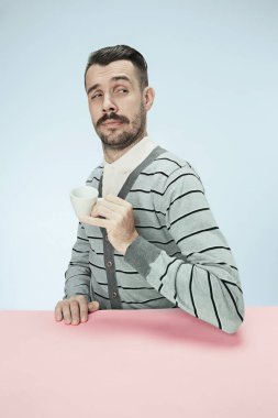 stüdyoda oturan ve kahve fincan elinde tutan üzülmüş yalnız adam. Tonda portre portre