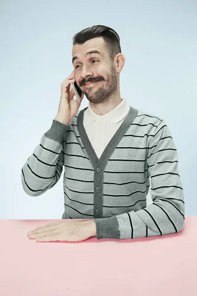 Homme d'affaires heureux souriant parlant au téléphone assis à la table — Photo