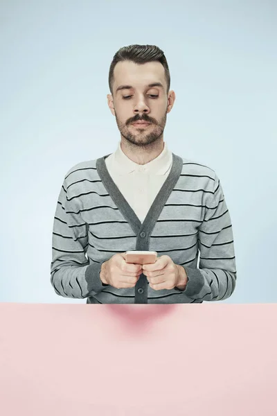Ciddi iş adamı ile hareket eden telefon masada oturan — Stok fotoğraf